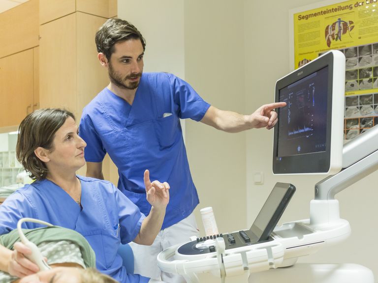 Ärztin und Arzt diskutieren Befund am Ultraschallgerät.