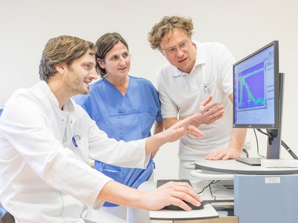 Ärzte diskutieren Befund am Computerbildschirm.